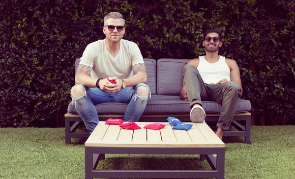 Two guys sitting on a couch outside