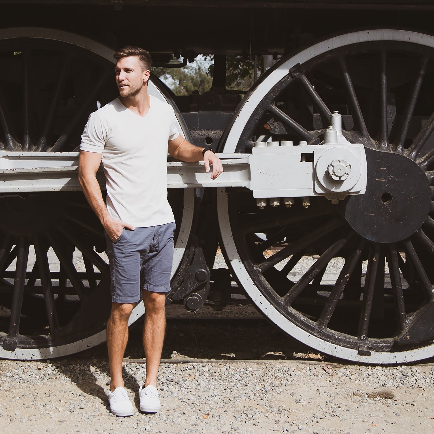 Man wearing a True Classic White T-shirt standing in front of a large train