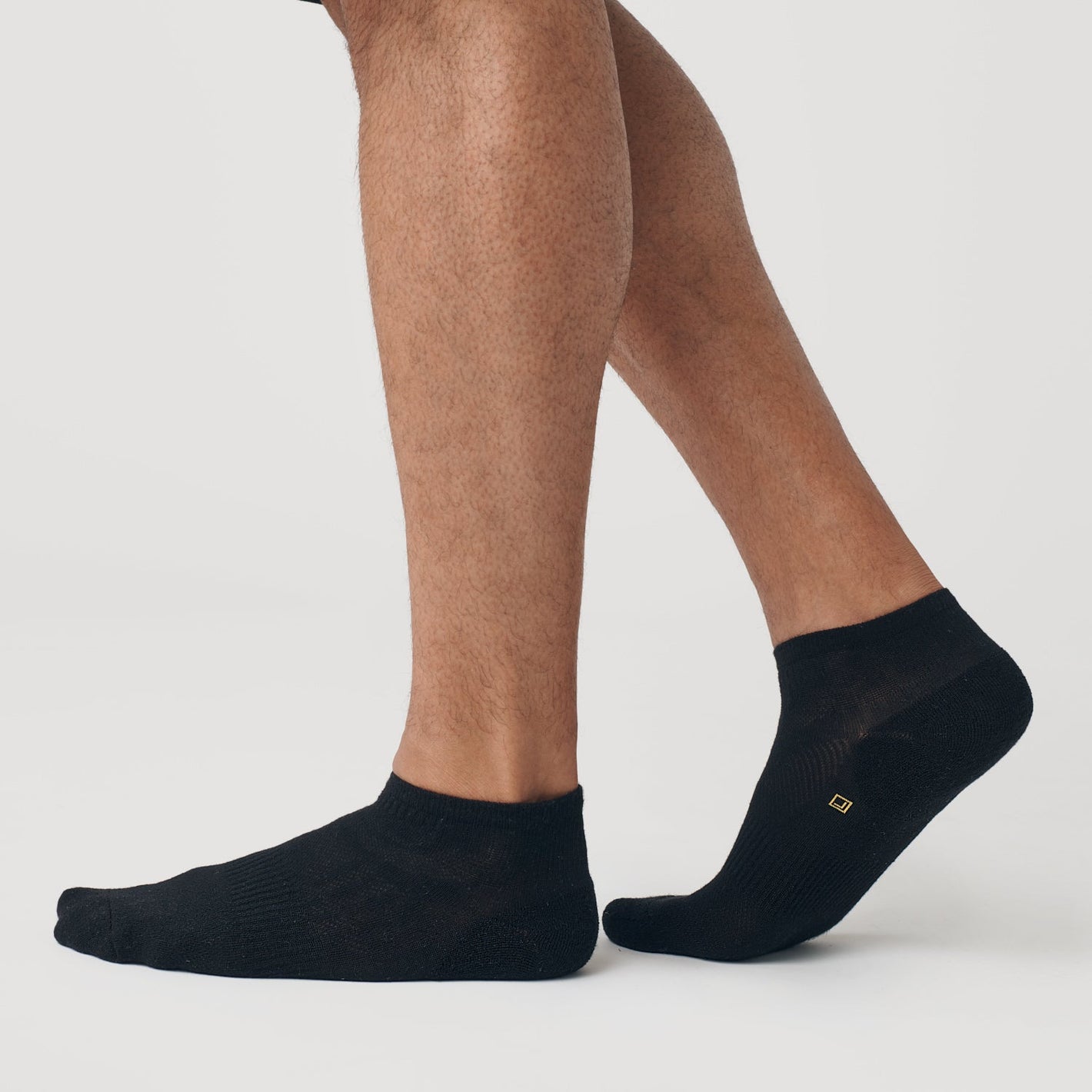 Black Ankle Socks Single on feet, seamless toe, subtle logo visible.
