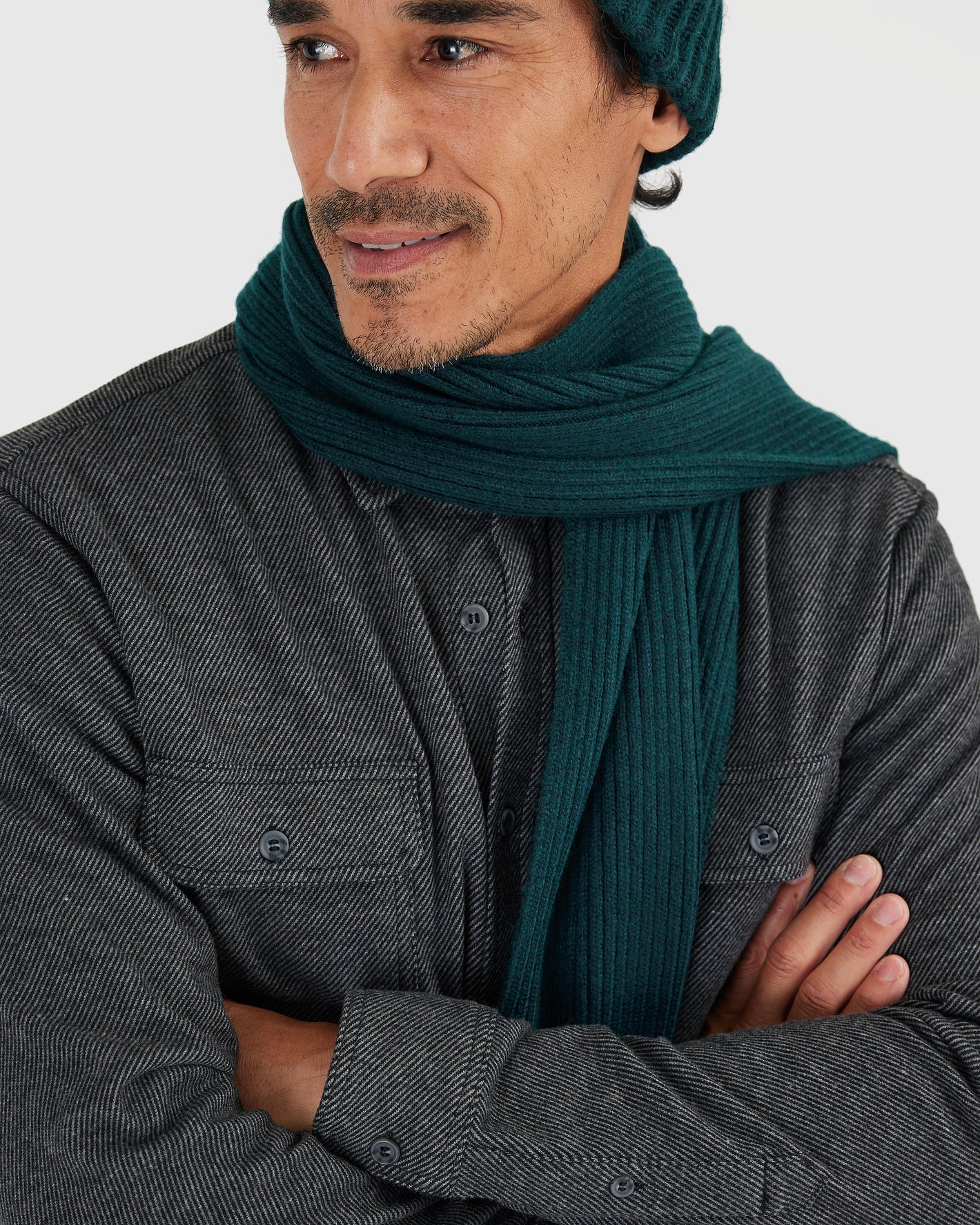 Man wearing Evergreen Sweater Scarf, dark charcoal-gray herringbone shirt.