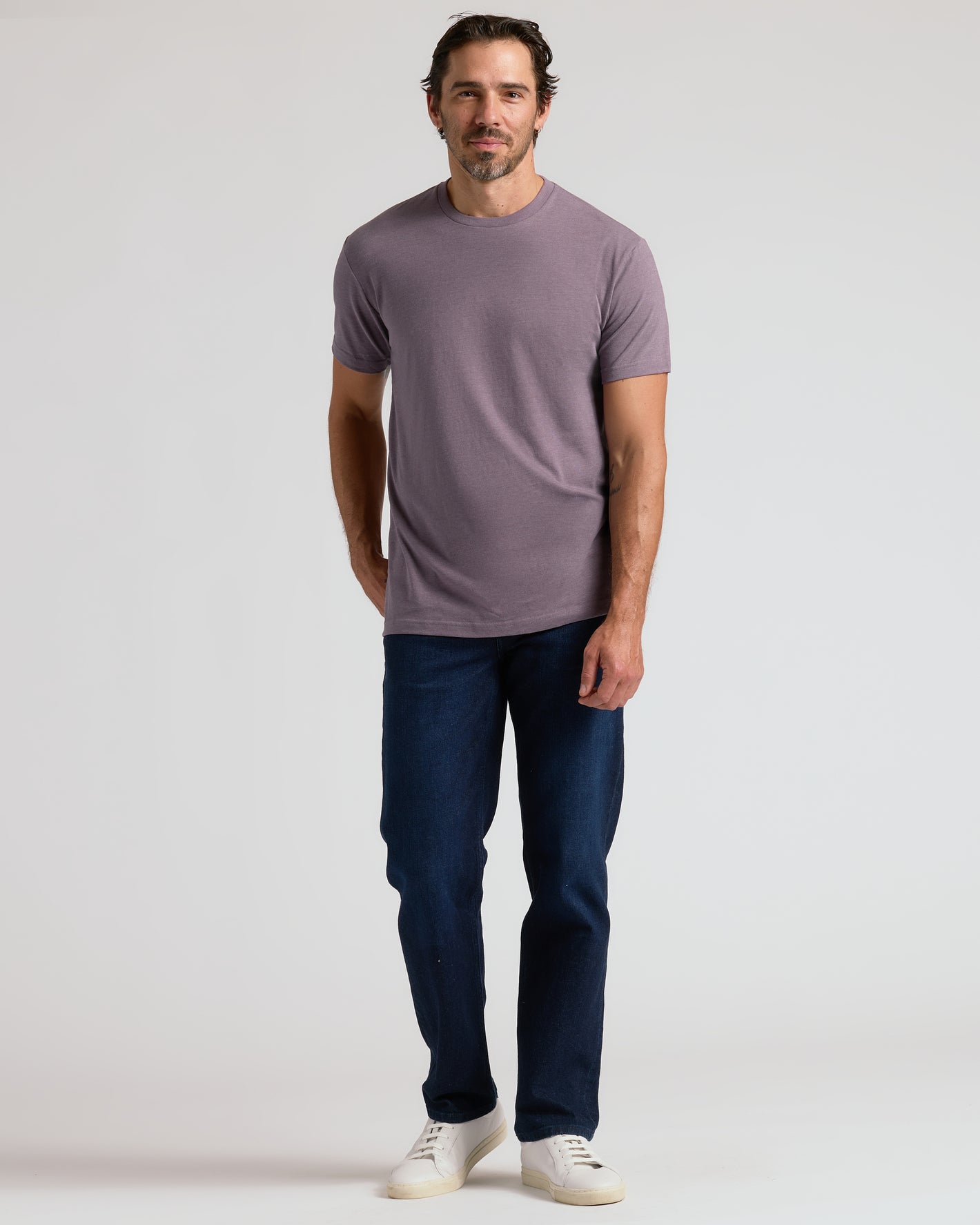 Man wearing Dark Heather Amethyst Classic Crew Neck and dark jeans.
