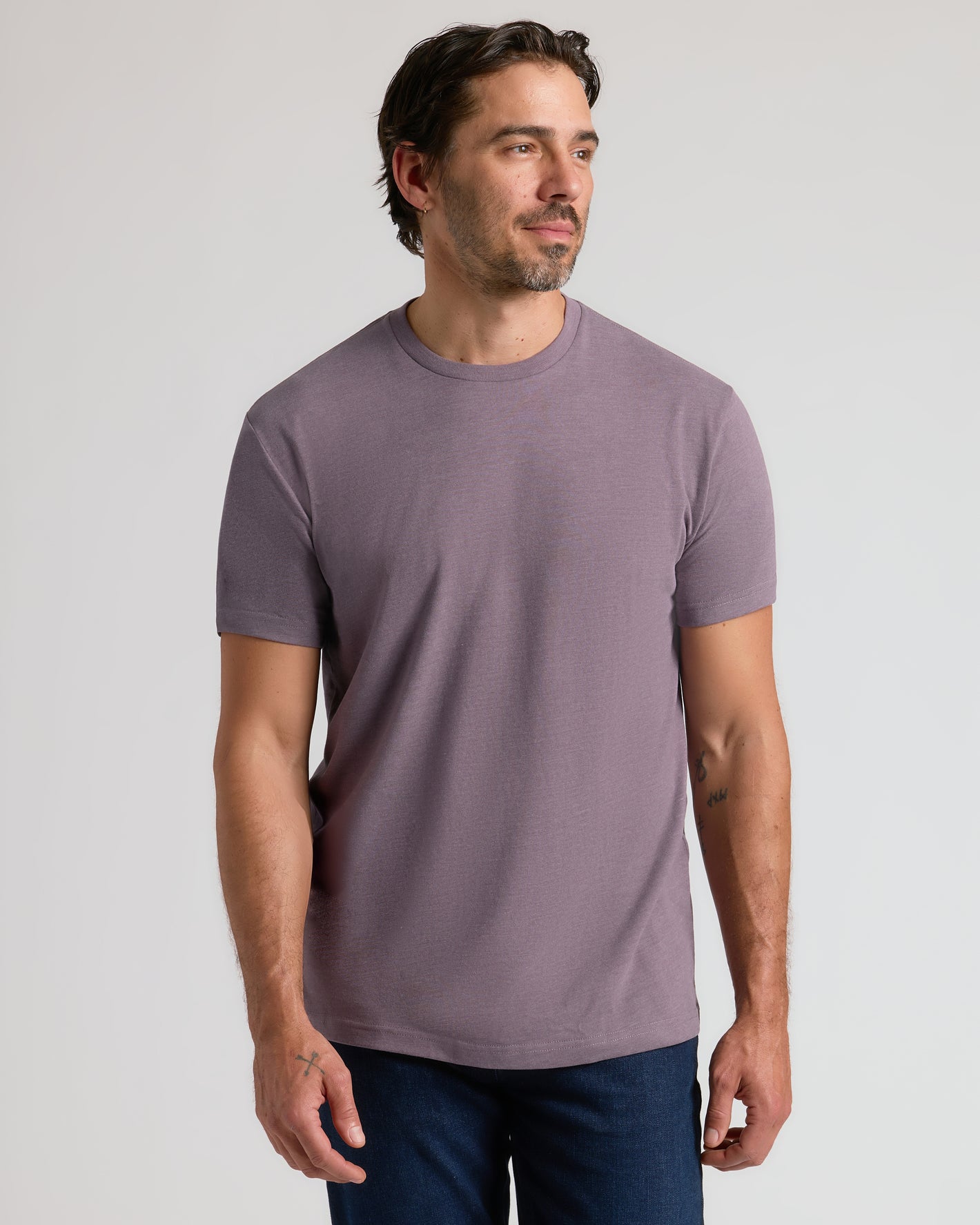 Man wearing Dark Heather Amethyst Classic Crew Neck, relaxed pose.