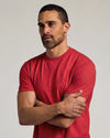 Man in Dark Heather Lava Short Sleeve Crew Neck Tee, arms crossed.