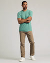 Man wearing Light Heather Greenery Classic Crew Neck and khaki pants.