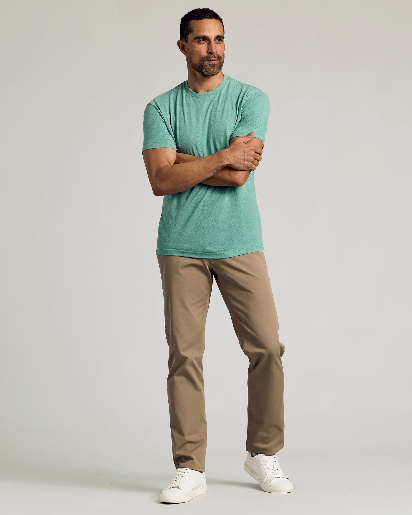 Man wearing Light Heather Greenery Classic Crew Neck and khaki pants.