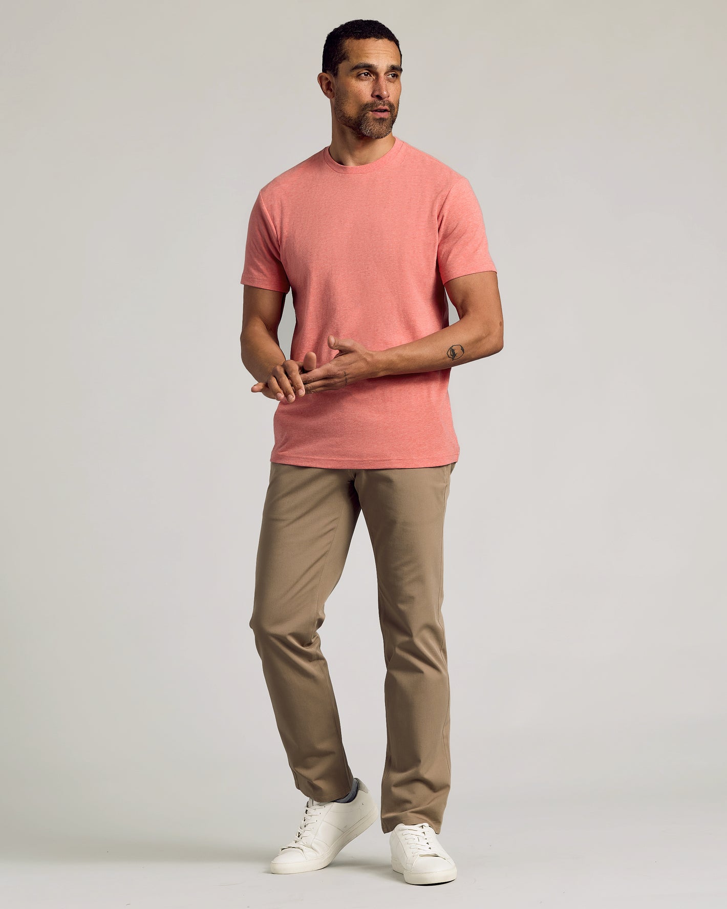 Man in Light Heather Vermilion Classic Crew Neck, khaki pants, white sneakers.