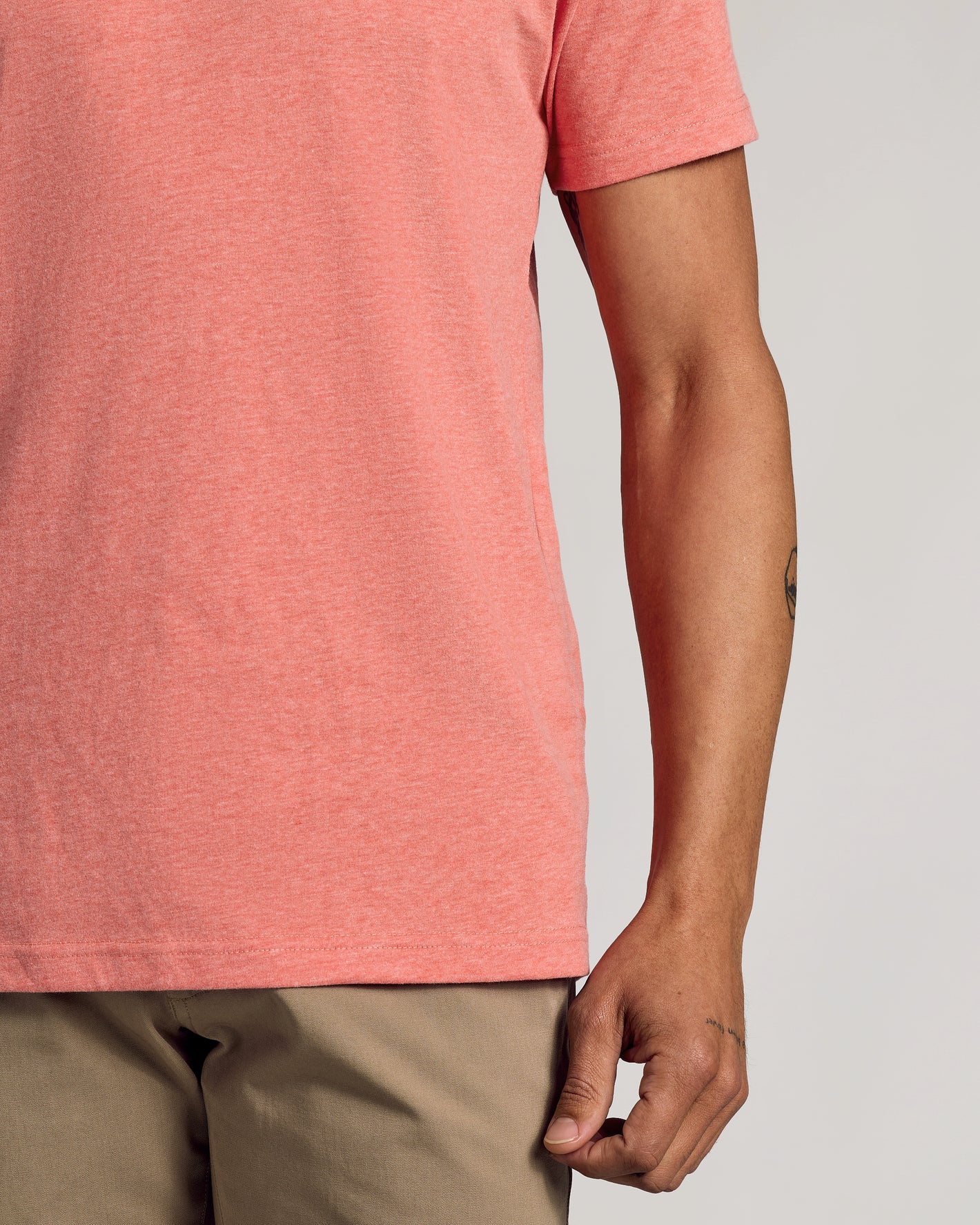 Light Heather Vermilion Classic Crew Neck with khaki pants, forearm tattoo visible.
