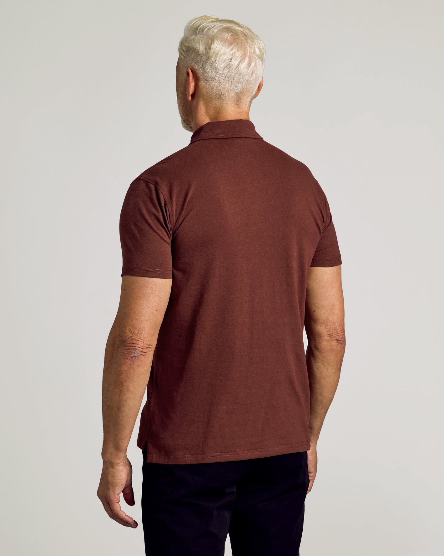 Dark Chocolate Short Sleeve Polo worn by man, back view.