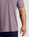 Man wearing Dark Heather Amethyst Short Sleeve Polo with black palm-tree tattoo.