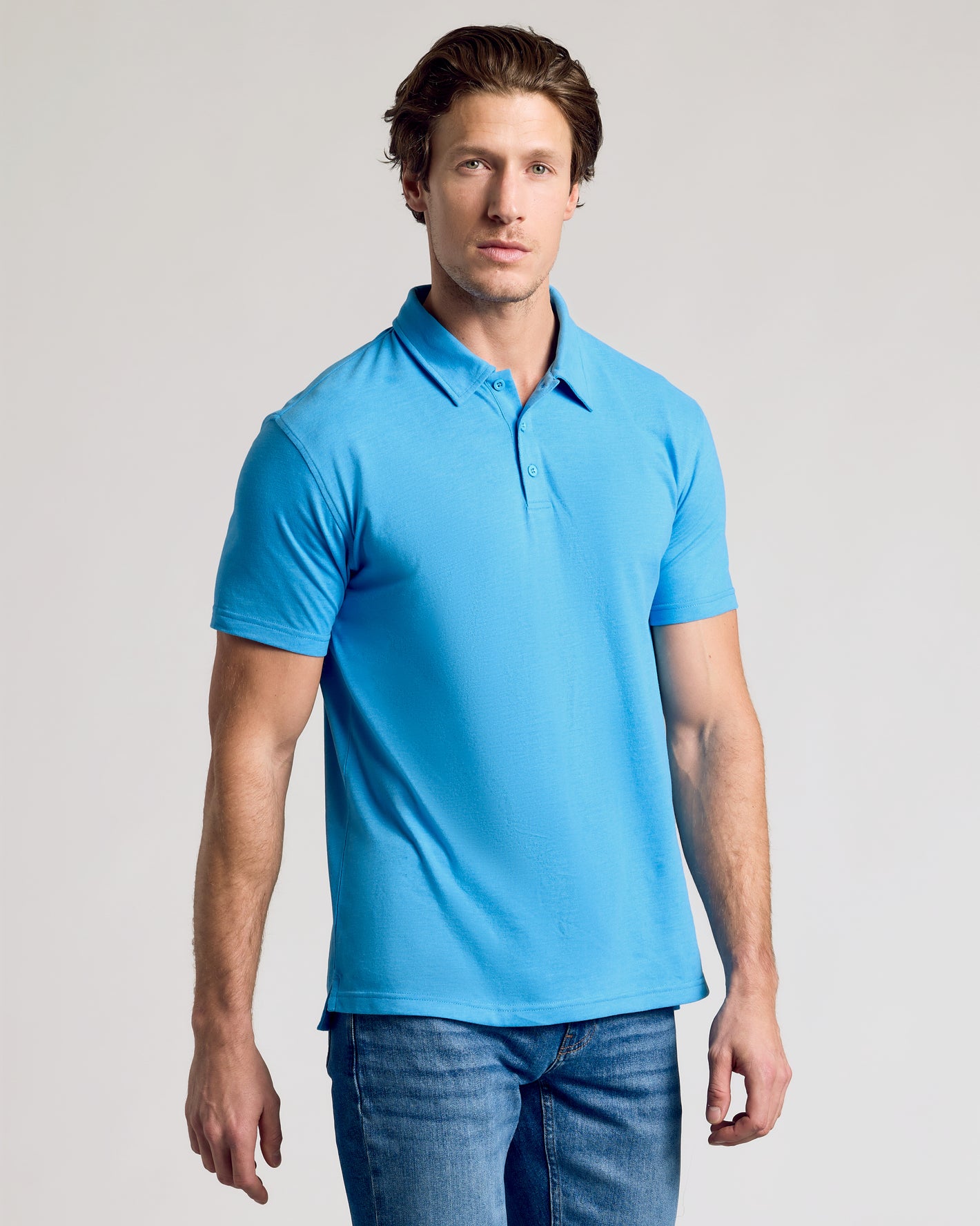 Man wearing Dark Heather Bahama Blue Short Sleeve Polo with jeans.