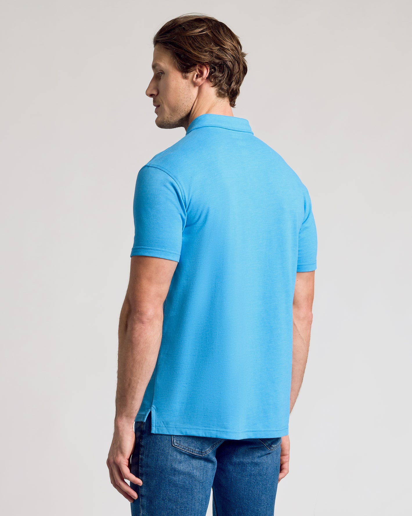 Back view of Dark Heather Bahama Blue Short Sleeve Polo on model.