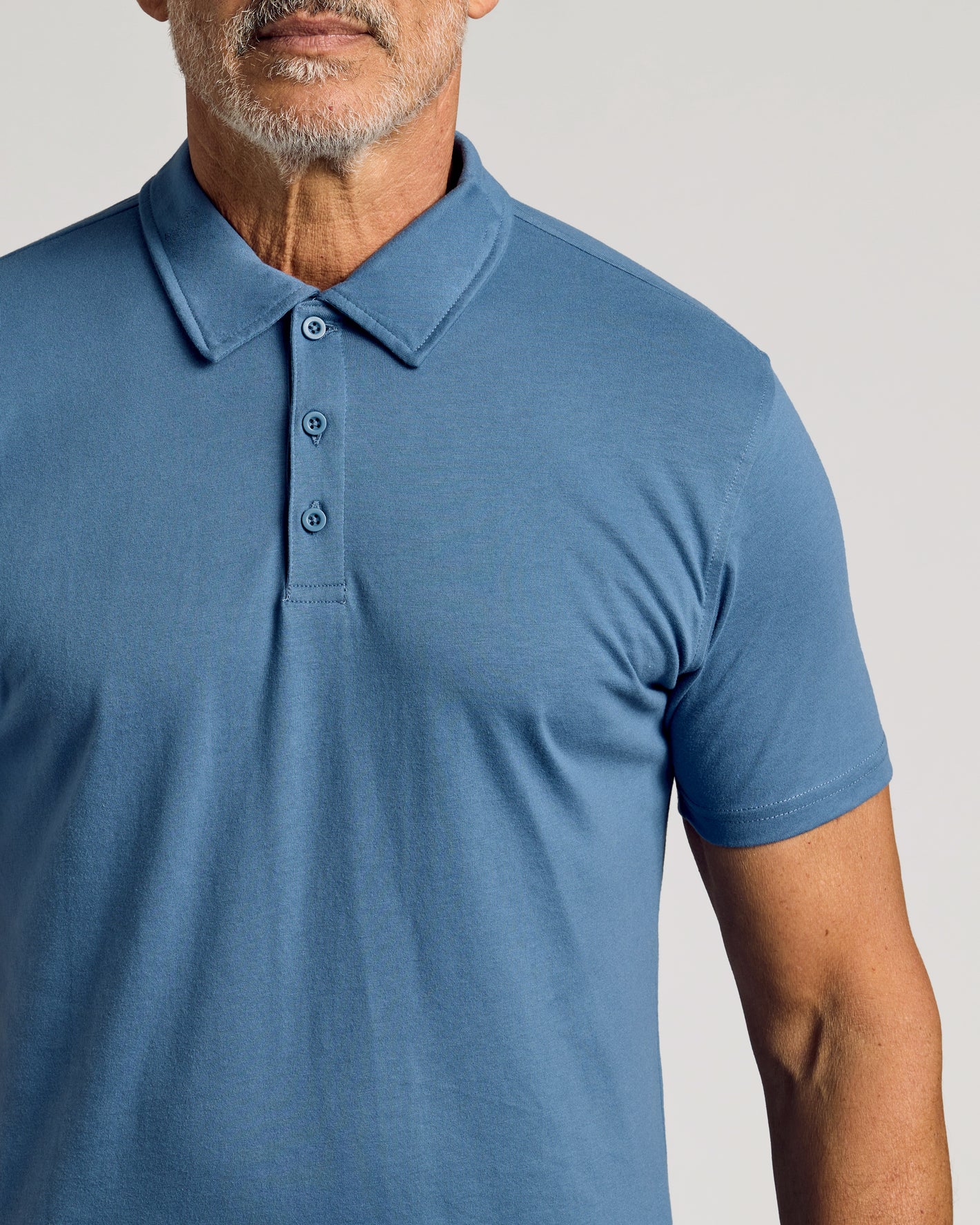 Older man wearing Fiord Classic Polo, muted blue, button-front style.