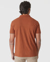 Back view of Heather Gingersnap Mane Classic Polo worn with khaki pants.
