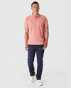 Man wearing Heather Cayenne Classic Polo and slim-fit jeans.