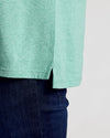 Light Heather Greenery Classic Polo with side slit, paired with jeans.