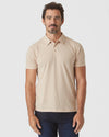 Man wearing Light Camel Cream Heather Polo with dark jeans.
