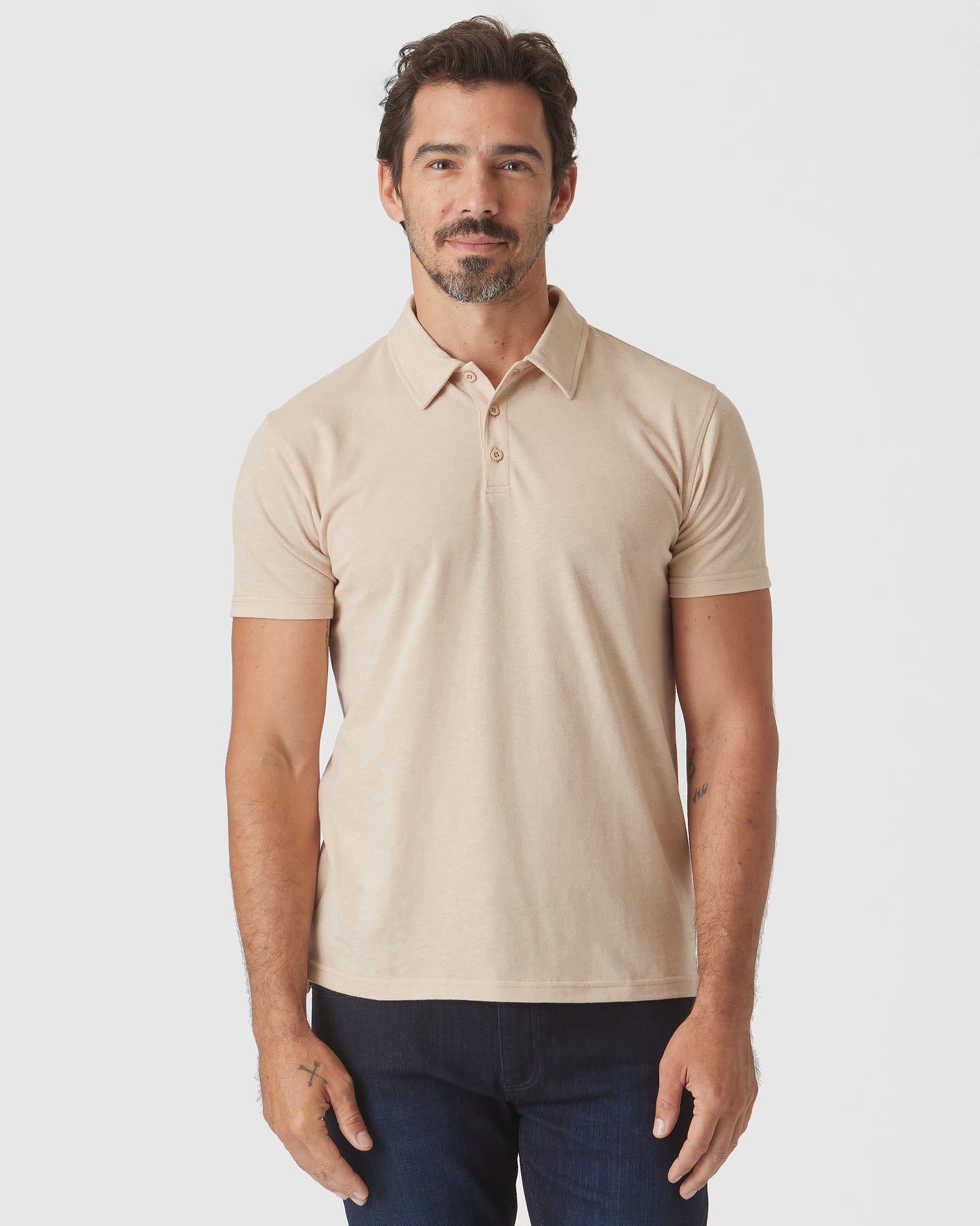 Man wearing Light Camel Cream Heather Polo with dark jeans.
