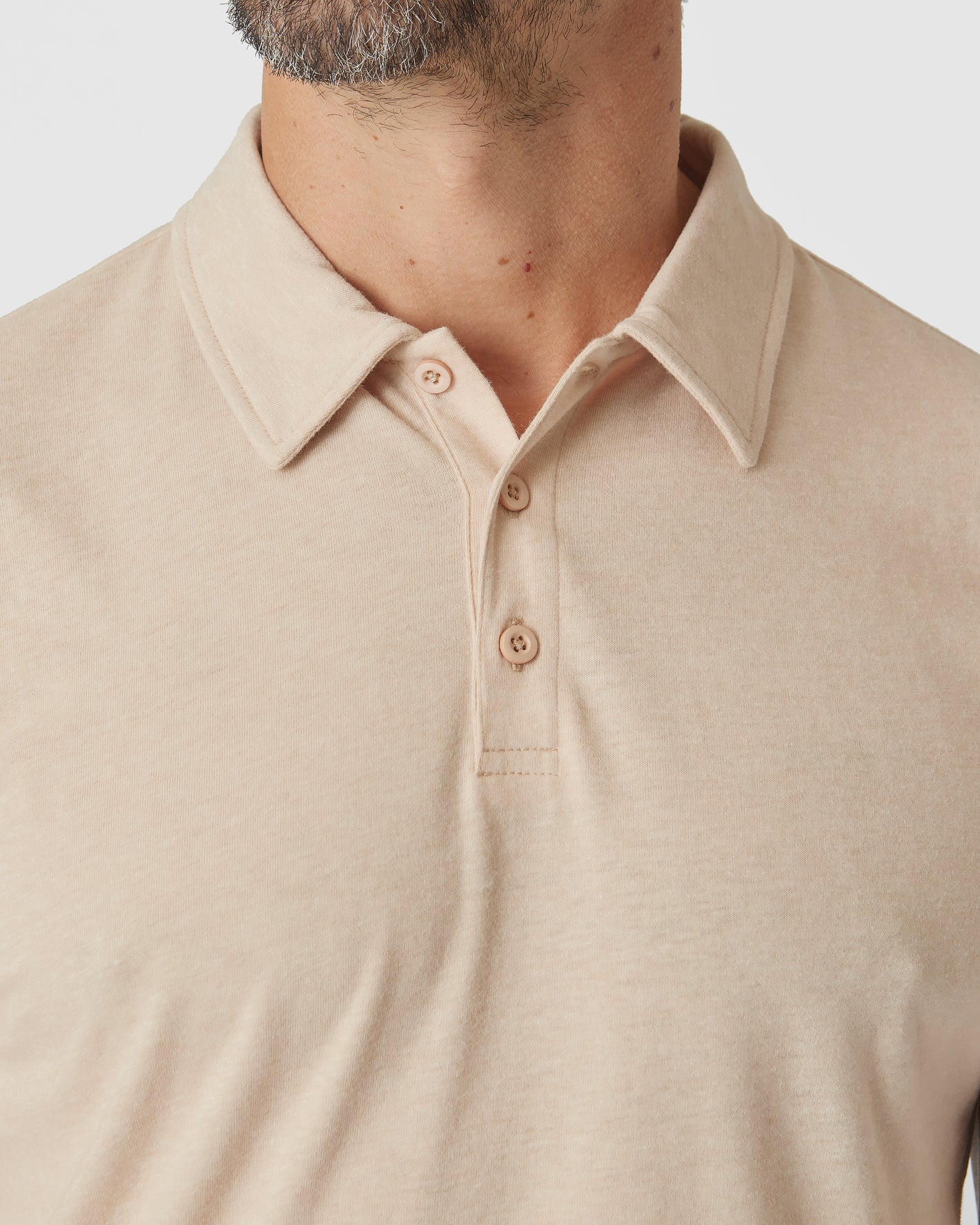 Light Camel Cream Heather Polo with collar and three-button placket.