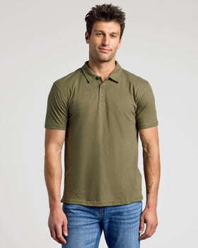 Man wearing Military Green Classic Polo and blue jeans, standing relaxed.
