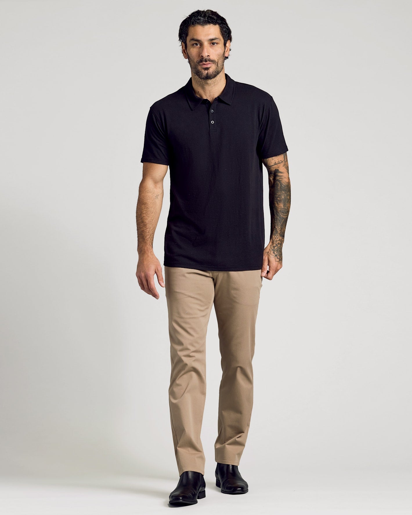 Model wears Classic Polo 6-Pack black shirt with tan trousers.