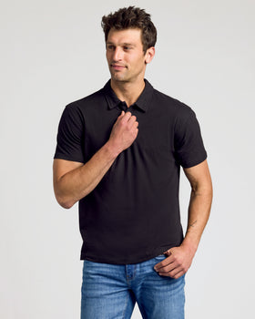 Young man wearing The Essentials Classic Polo 3-Pack in black.