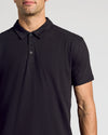 Man wearing Black & White Classic Polo 10-Pack, black polo shirt, script tattoo visible.