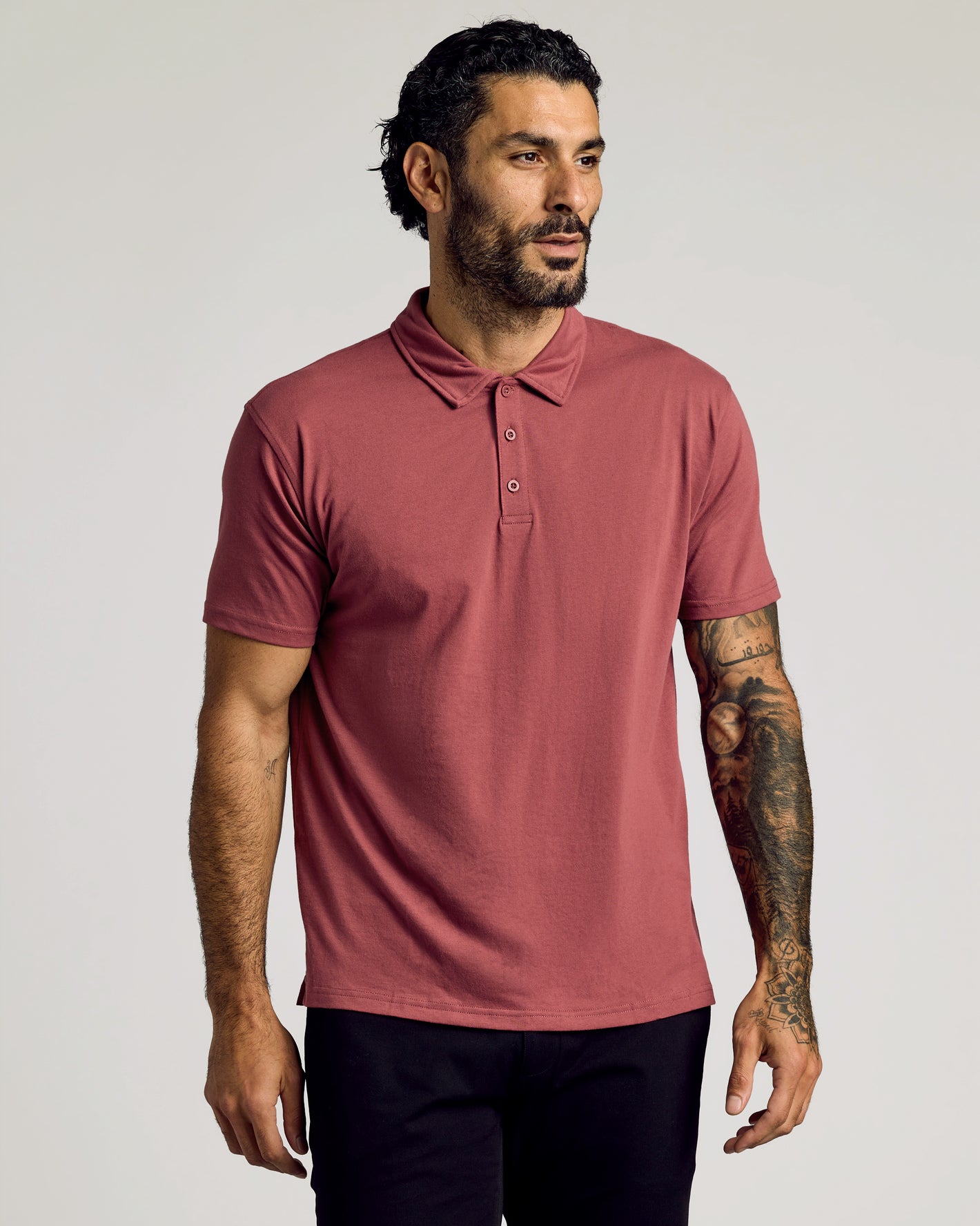 Man wearing Rustic Apple Classic Polo with tattoos on forearm.