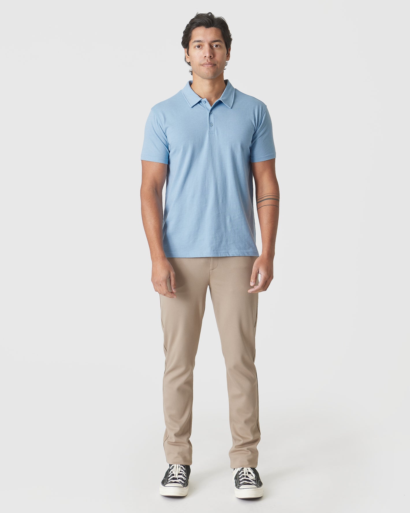 Young man wearing Sky Blue Heather Polo, showcasing its sleek, fitted design.