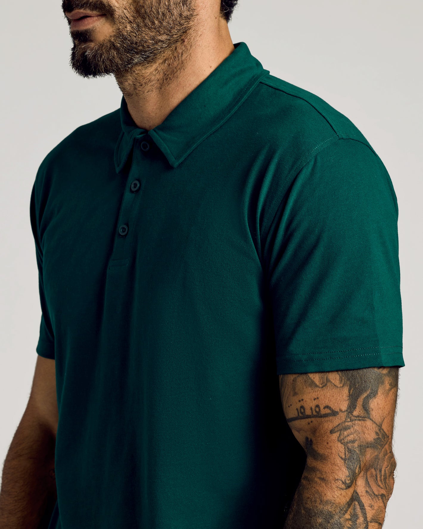 Man wearing Viridian Classic Polo, dark green, short-sleeve, three-button placket.