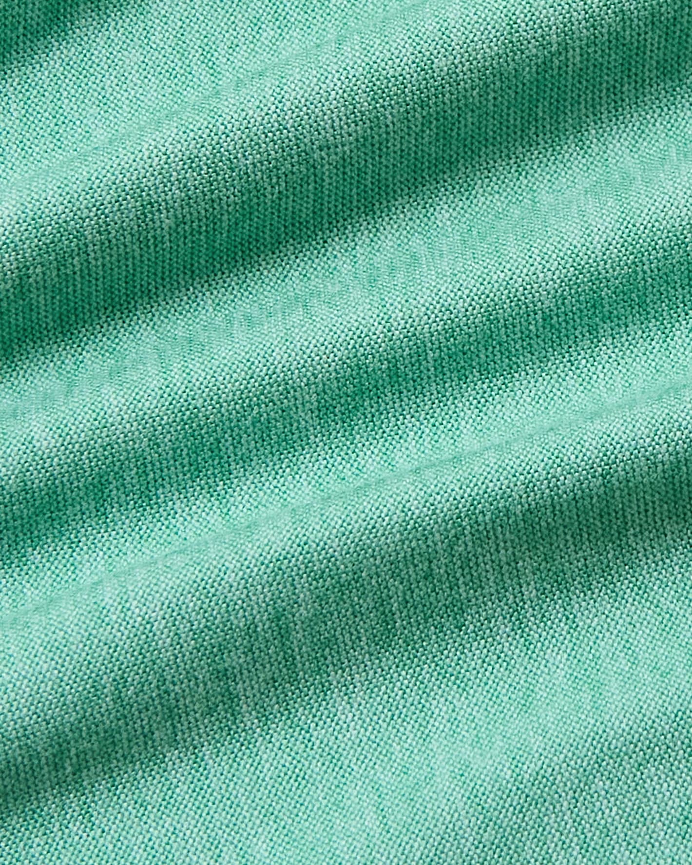 A close-up of mint green knit fabric with soft diagonal folds and visible woven texture.