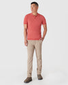 Man models Garnet Short Sleeve Sweater Polo with beige chinos and boots.