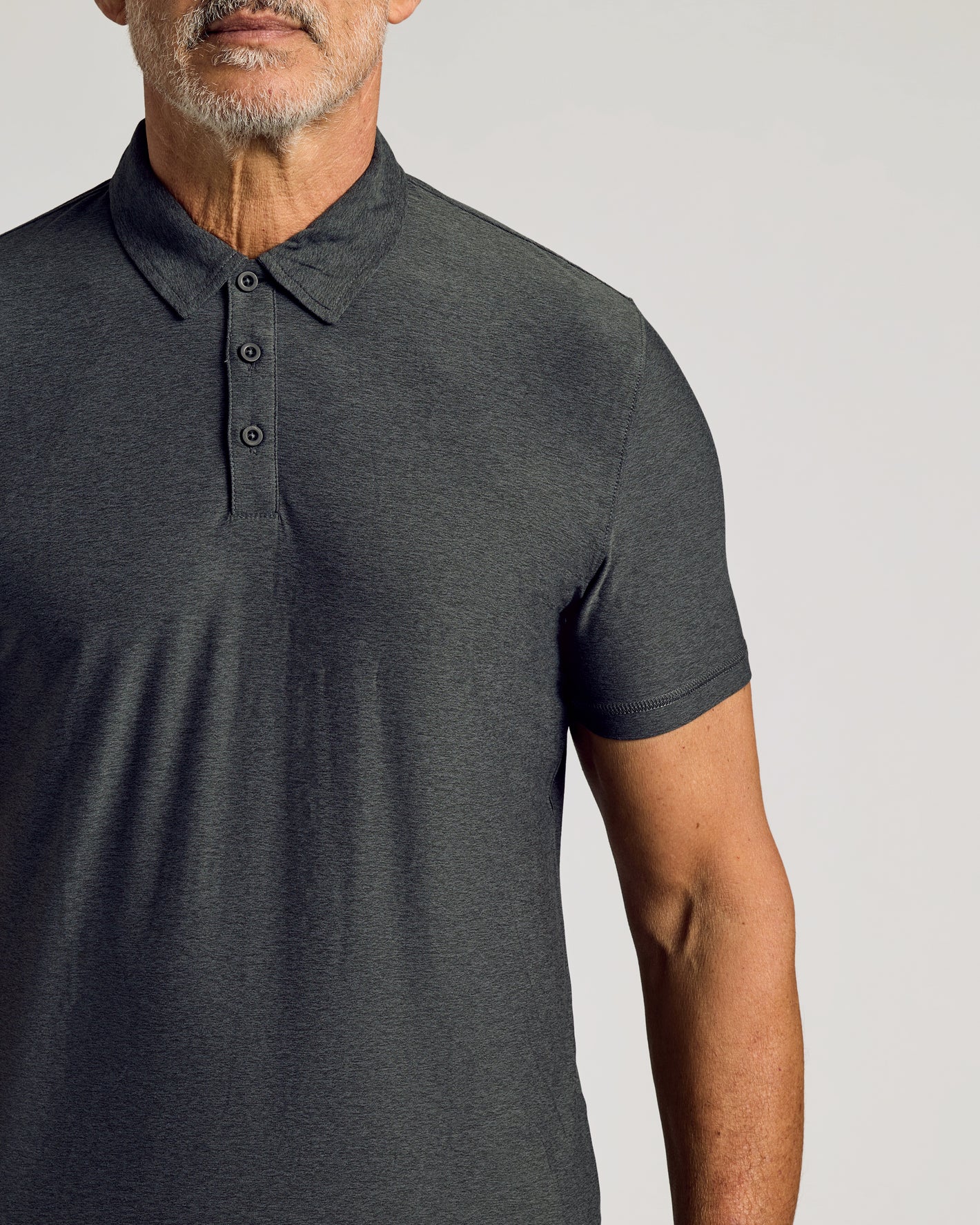 Man wearing Charcoal Heather Gray Active Polo 2.0 with collar and placket.