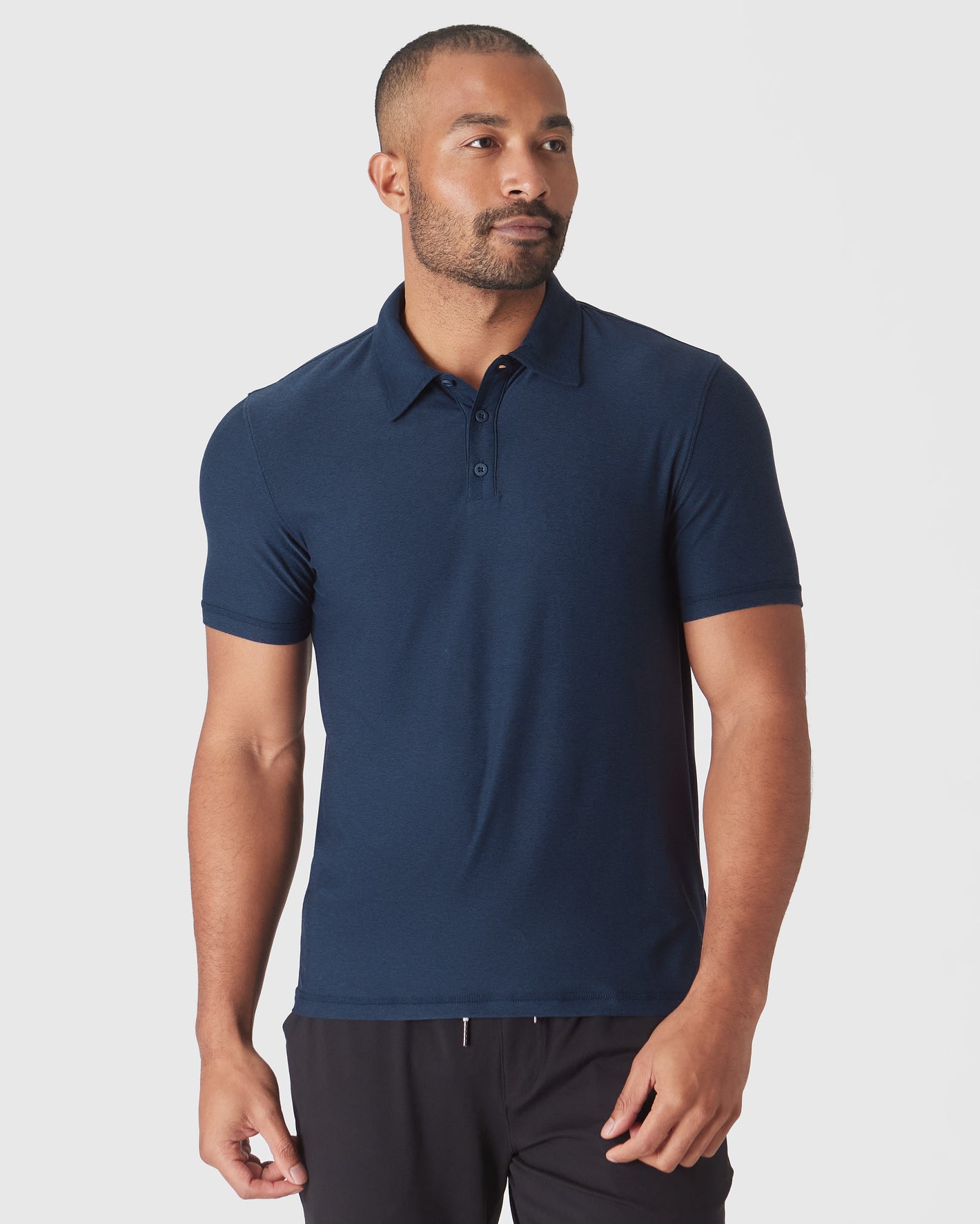 Man wearing True Classic Men’s Active Short Sleeve Polo with black pants.