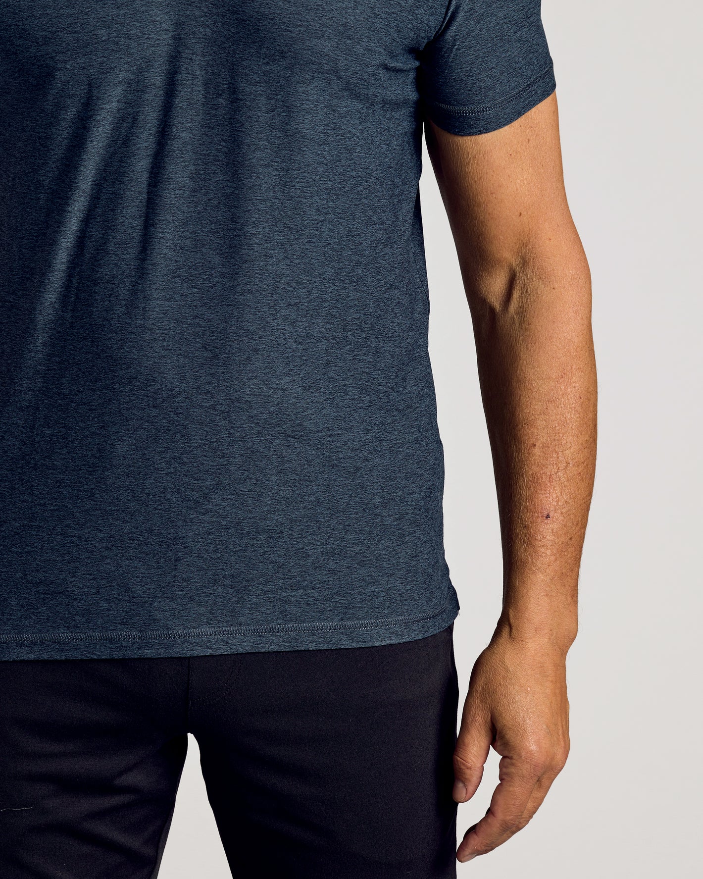 Dark Heather Fiord Active Polo 2.0 on model, showcasing midsection and right arm.