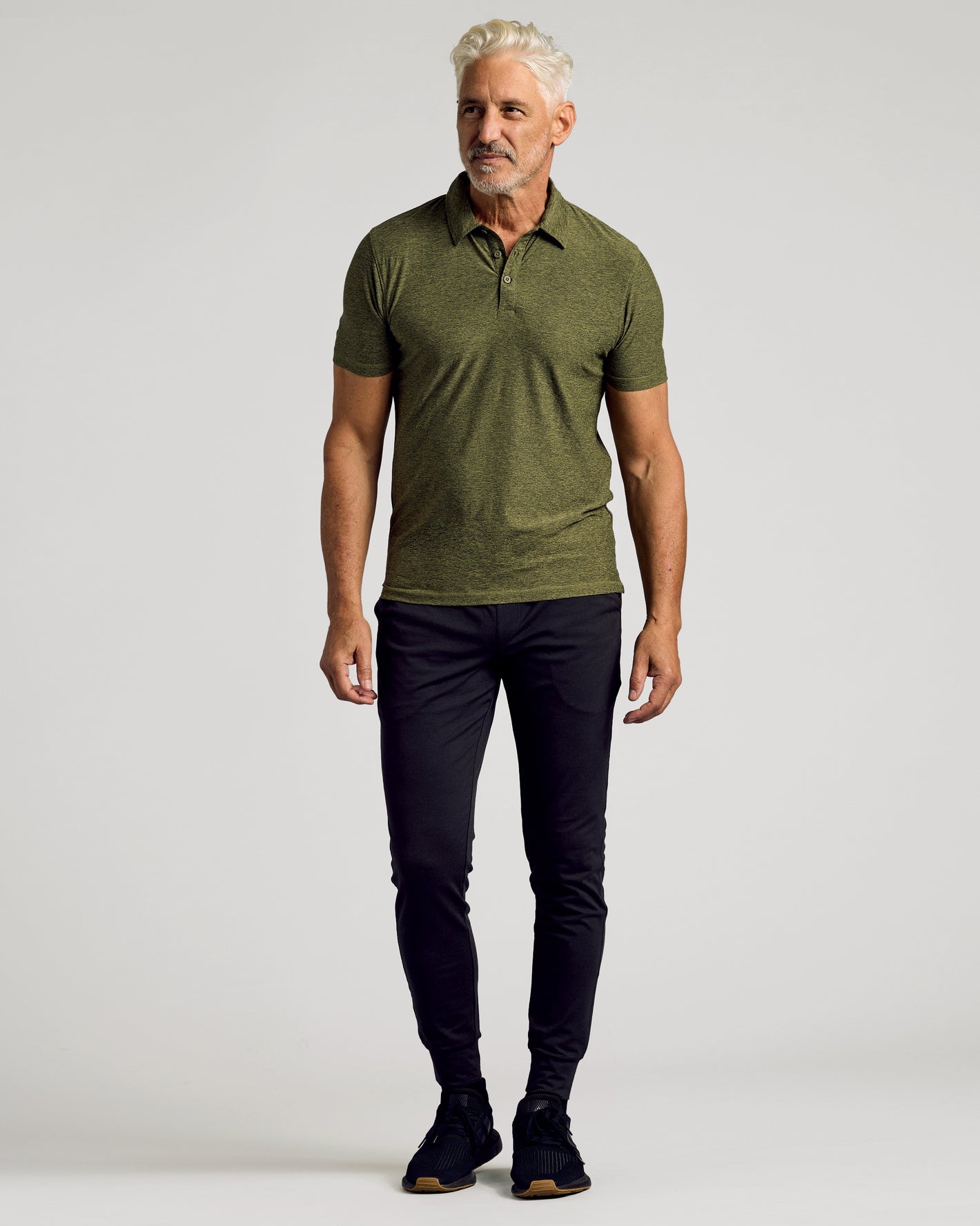 Middle-aged man wearing Dark Heather Pear Active Polo 2.0 and black pants.
