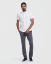 Man wearing White Short Sleeve Commuter Shirt 2-Pack, relaxed posture, gray trousers.