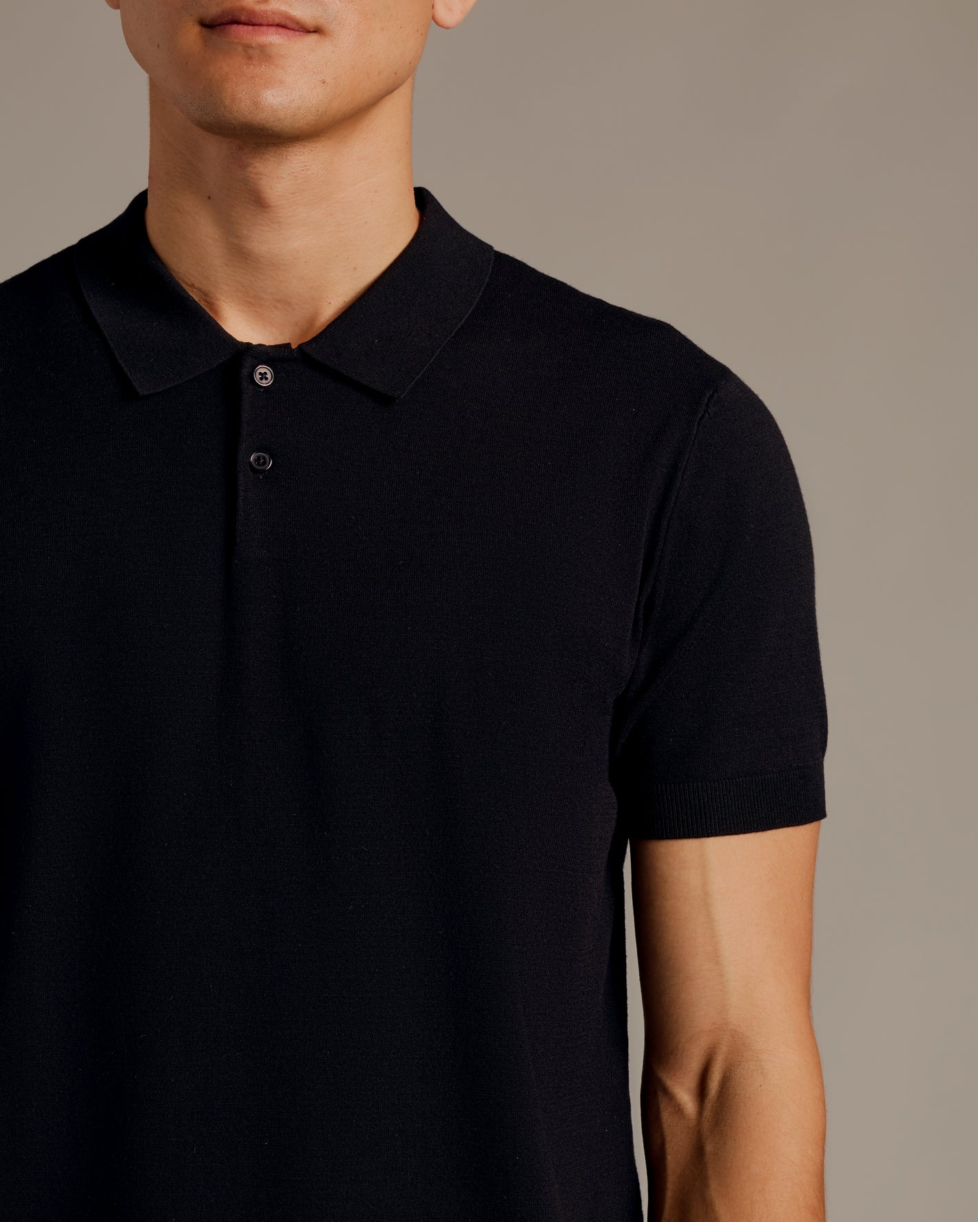 Man wearing All Black Dressy Polo from 3-Pack; sleek, short-sleeve design.