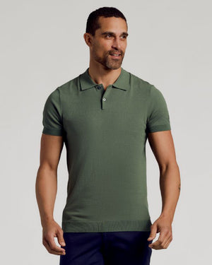 Model in Moss Dressy Polo, olive green, with dark trousers.