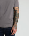 Carbon Premium Pima Crew Neck worn with tattooed forearm visible.