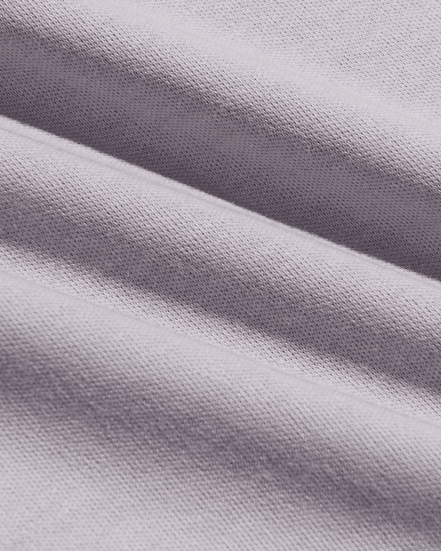 A close-up of draped light gray knit fabric with a fine ribbed texture and soft folds.