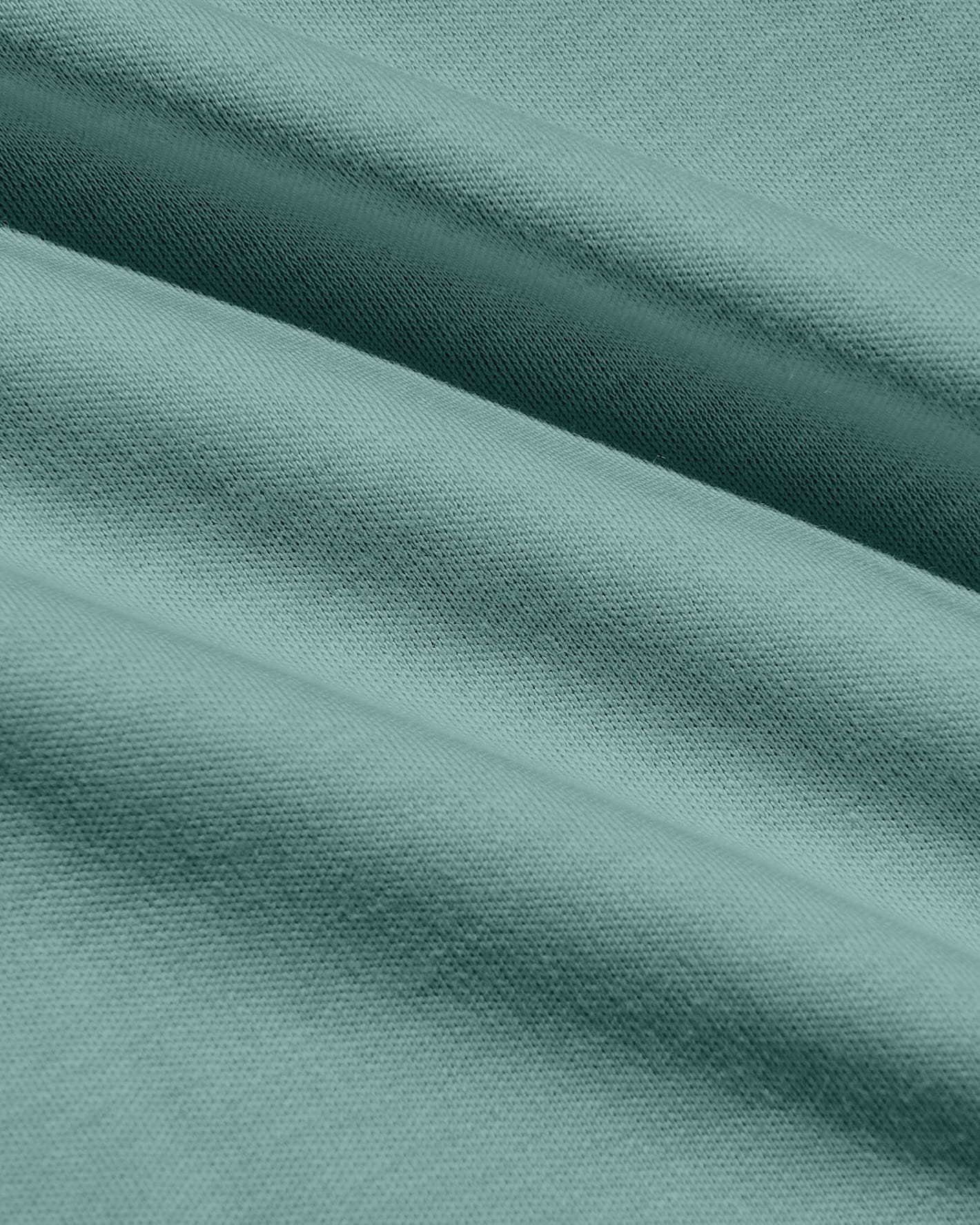 A close-up of draped fabric in a muted sage green color, showing the texture and weave with soft folds.