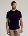 Man wearing Black Curved Hem Classic Crew Neck T-shirt with tan trousers.