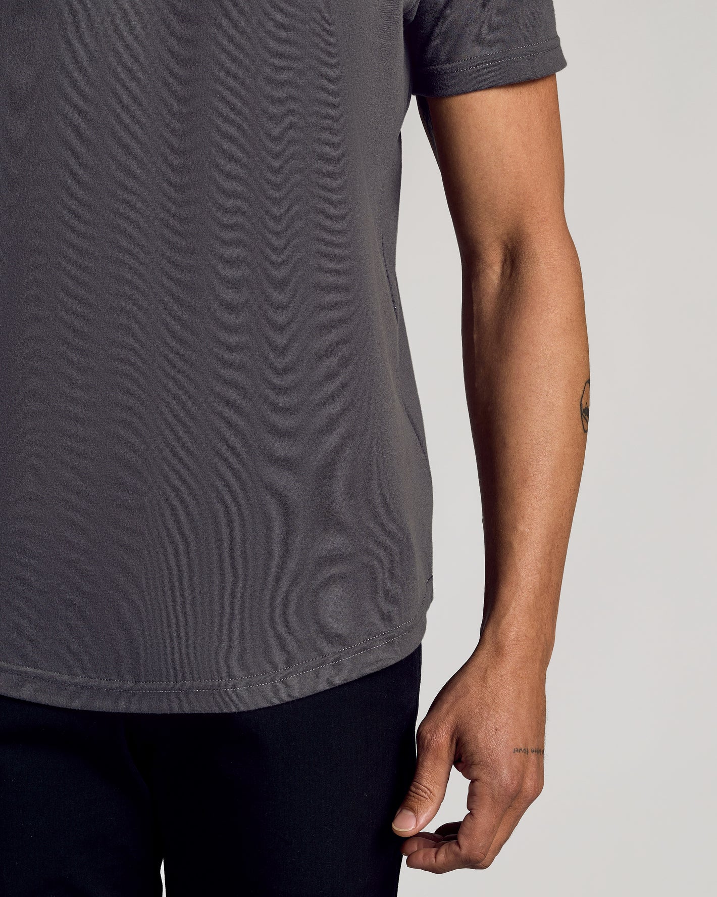 Carbon Curved Hem Classic Crew Neck on person, showcasing fit and tattoo accents.