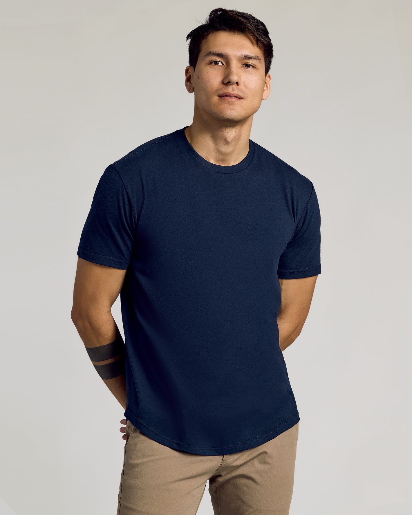 Young man wearing Navy Curved Hem Classic Crew Neck and khaki pants.
