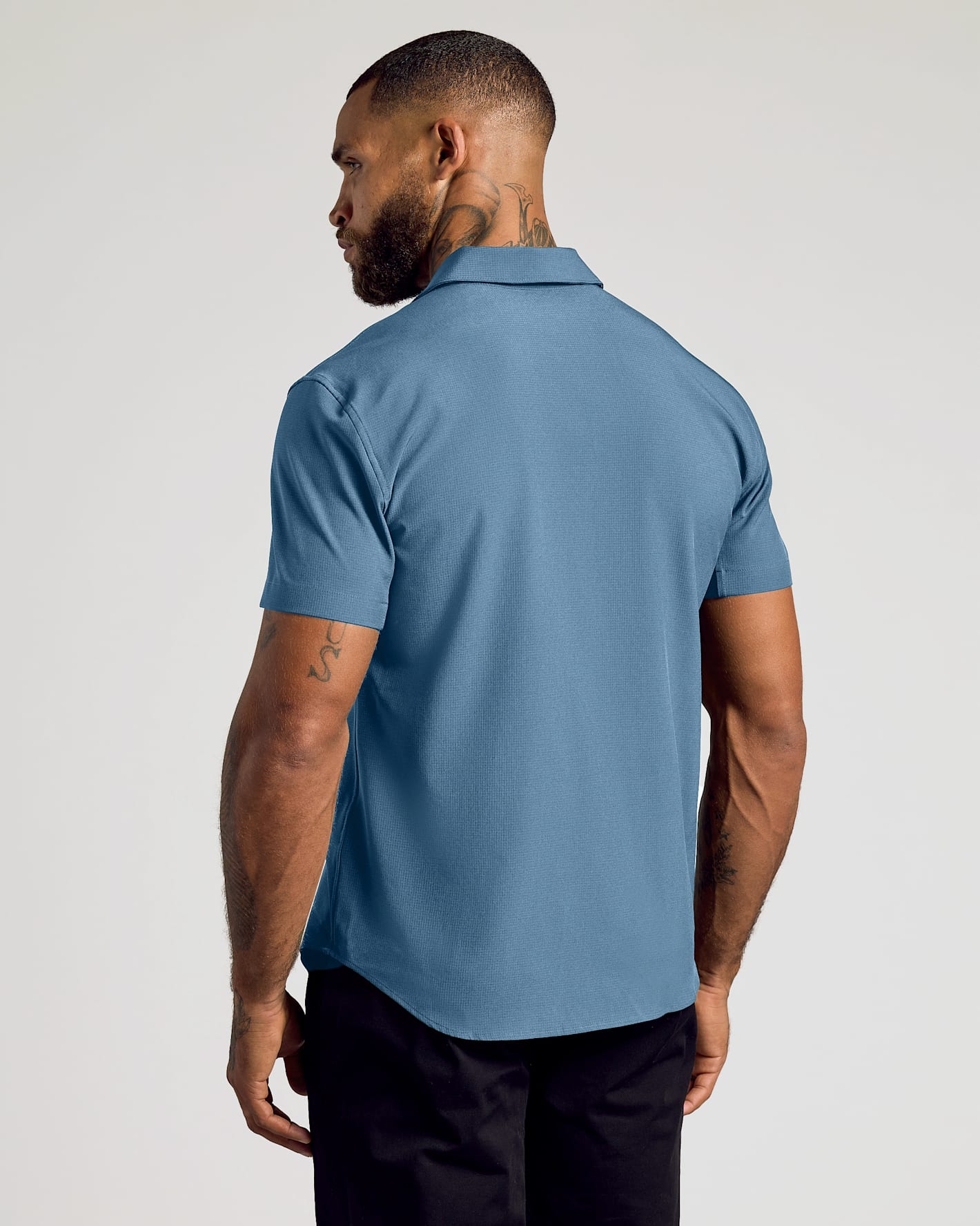 Man in Short Sleeve Ripstop Commuter Shirt showcasing back view.