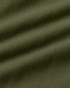 A close-up of olive green fabric with a fine woven texture and soft diagonal folds.