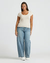 Woman wearing Womens Oatmeal Ribbed U-Neck Tee, blue jeans, and sneakers.