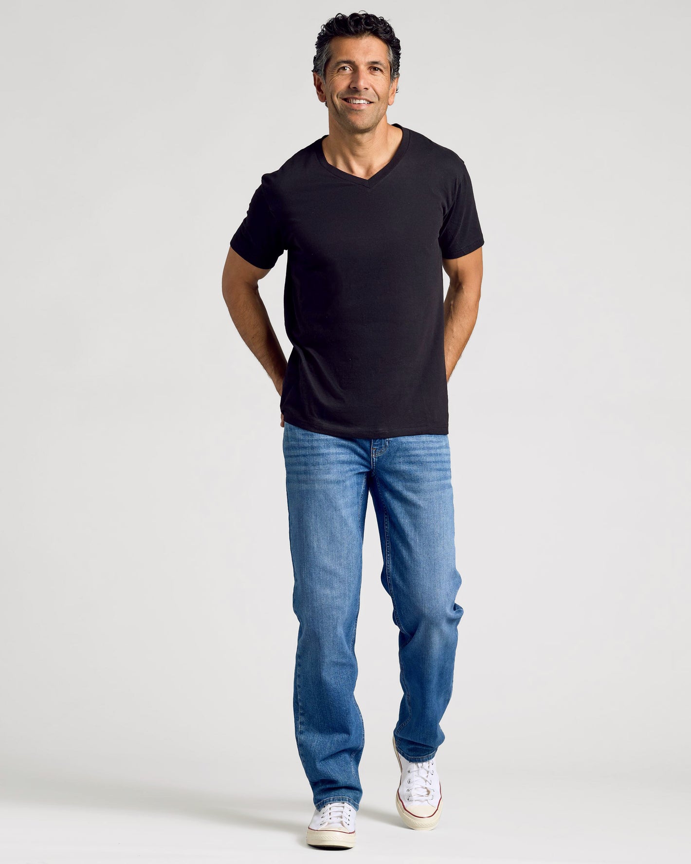 Man wearing All Black Classic V-Neck T-shirt, smiling casually.