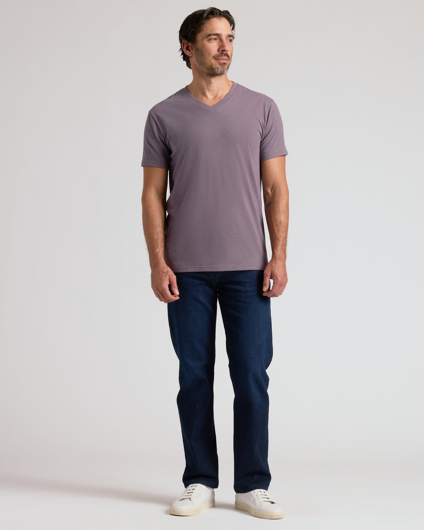 Man in Dark Heather Amethyst Classic V-Neck, jeans, and sneakers.