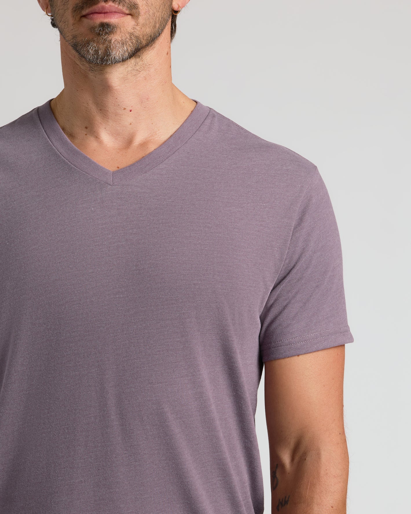 Man wearing Dark Heather Amethyst Classic V-Neck T-shirt, showcasing neckline.